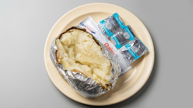 Baked potato in foil served with butter and sour cream at Betty's Bar-B-Q in Anniston, AL
