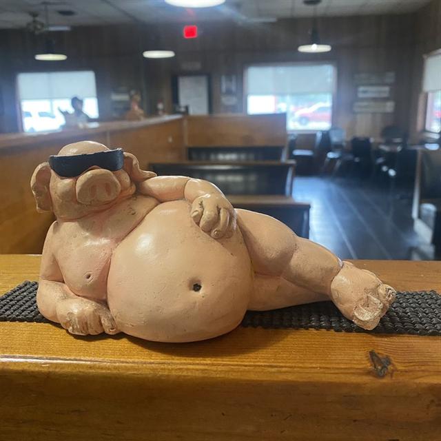 Betty's lounging pig statue wearing sunglasses inside the dining room
